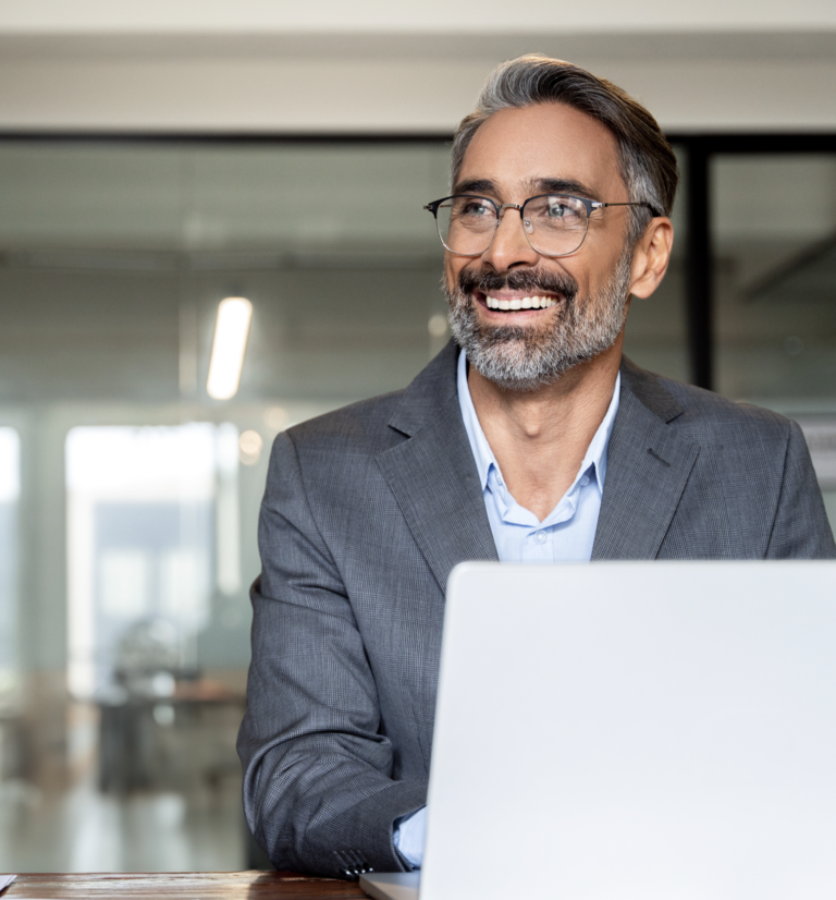 A smiling man with a laptop.