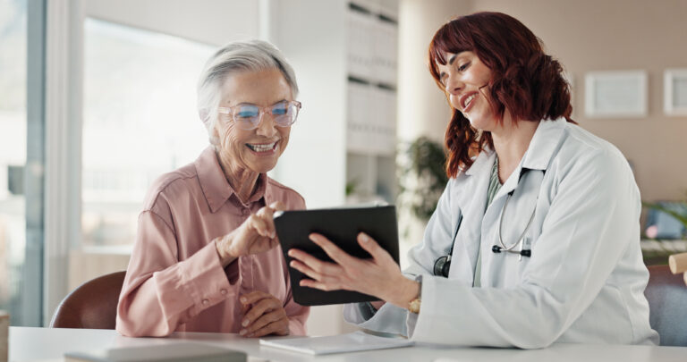 Smile, old woman and doctor with tablet for results, consultation or healthcare discussion in office. Advice, senior patient and medical professional on digital app for health, wellness and good news.